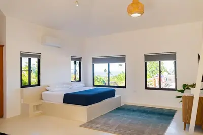 a bedroom with a bed with blue sheets and windows at Private Villa-Infinity Pool-26 guests capacity-14 King Size Beds-8 bedrooms-8 and half baths in Cabrera