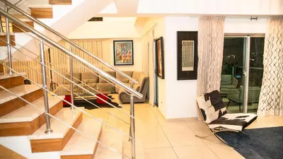 a living room with a staircase and a chair at Eclectic 3 levels and 5 bedrooms penthouse in Santo Domingo