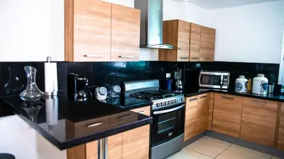 a kitchen with wooden cabinets and a stove top oven at 3 levels and 5 bedrooms penthouse with a great view in Santo Domingo