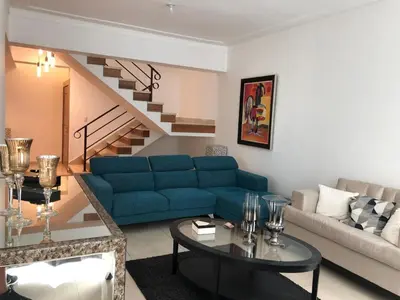 a living room with a blue couch and a staircase at 3 levels and 5 bedrooms penthouse with a great view in Santo Domingo