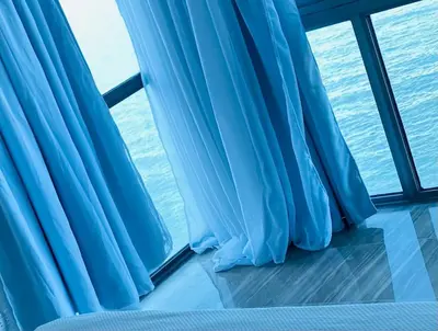 a window with blue curtains on a cruise ship at Vista al mar Hab Privada Larimar, Malecon Santo D in Santo Domingo