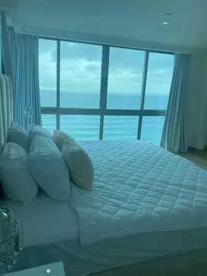 a bed in a room with a large window at Vista al mar Hab Privada Larimar, Malecon Santo D in Santo Domingo