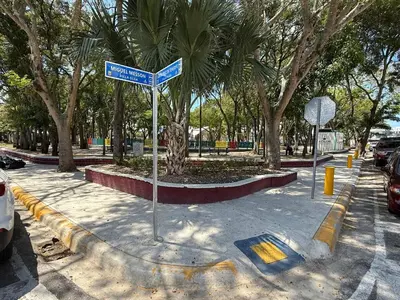 a street sign in the middle of a street with trees at Confortable apartamento en Villa Olga in Santiago de los Caballeros