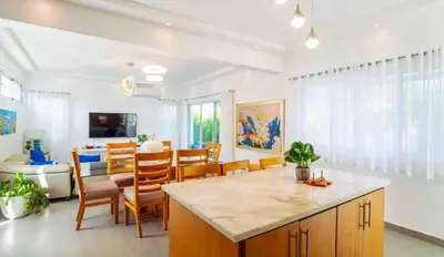 a kitchen and living room with a table and chairs at Sunbreeze Villa in Oceanfront Sosua Ocean Village in Sosúa