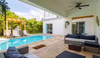 a living room with a pool and a ceiling fan at Sunbreeze Villa in Oceanfront Sosua Ocean Village in Sosúa