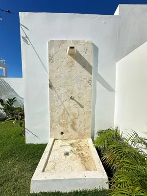 a stone shower in the side of a white wall at Villa Solana in Oceanfront Com Sosua Ocean Village in Sosúa