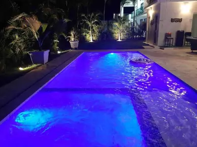 an infinity pool with purple and blue lighting at Modern Villa in Oceanfront Sosua Ocean Village in Sosúa