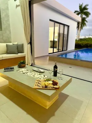 a living room with a table with wine glasses at Coral Villa in Oceanfront Comm Sosua Ocean Village in Sosúa