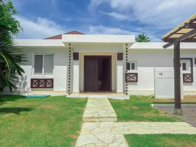 a large white house with a grass yard at Ocean View Villa in Oceanfront Sosua Ocean Village in Sosúa