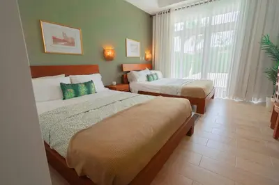 a hotel room with two beds and a window at Ocean View Villa in Oceanfront Sosua Ocean Village in Sosúa