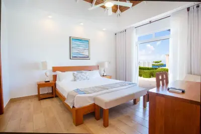 a bedroom with a bed and a desk and a window at Ocean Haven Oceanfront in Sosua Ocean Village in Sosúa