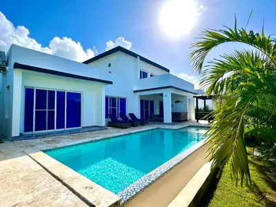 a villa with a swimming pool in front of a house at Sunset Villa in Oceanfront Sosua Ocean Village in Sosúa
