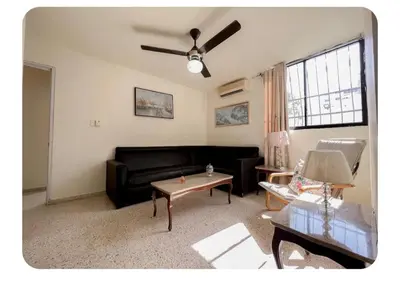 a living room with a black couch and a table at Hermoso apartamento en piantini Santo Domingo RD in La Julia
