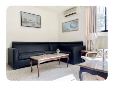 a living room with a black couch and a table at Hermoso apartamento en piantini Santo Domingo RD in La Julia