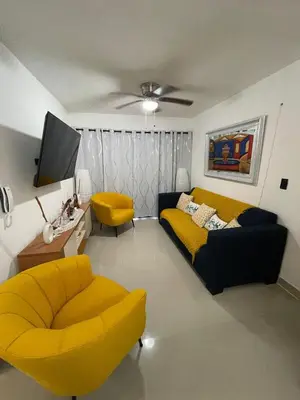 a living room with a couch and a tv at Romana Residence Vacationing Apartment in Cumayasa Kilómetros Diez