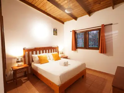 a bedroom with a bed with yellow pillows and a window at Villa silenziosa e sicura al centro di Las Galeras in Las Galeras