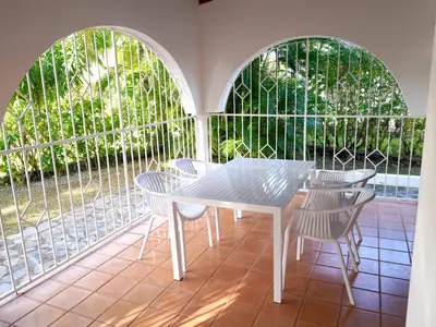 a white table and chairs on a screened in porch at Villa silenziosa e sicura al centro di Las Galeras in Las Galeras