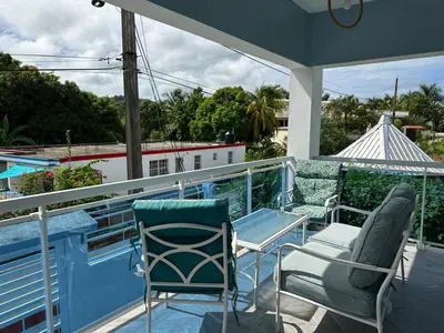 a balcony with chairs and a table and a pool at Villa kiyana-14 pax, 5min de la playa en Las Galeras in Las Galeras