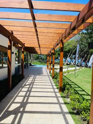 a wooden canopy over a walkway in a park at Marien Residences 221 Garden & Partial Ocean View Condo in Puerto Plata