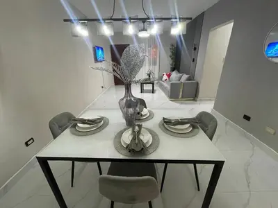 a dining room table with chairs and a vase on it at Cerca del aeropuerto los frailes I in Los Frailes