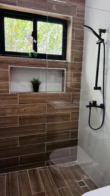 a bathroom with a shower with a glass wall at Villa YOSYMART Poolside Retreat private WIFI Luxury BBQ side in Punta Cana