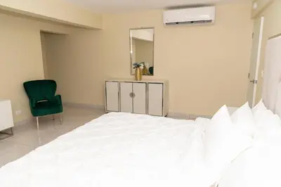 a bedroom with a bed and a mirror and a chair at La Isla Royal - Abismo Celeste in Miches