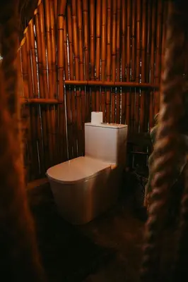 a bathroom with a toilet in a bamboo wall at OYA New Earth Luxury Romantic Glamping with Private Outdoor Bath in Jamao al Norte