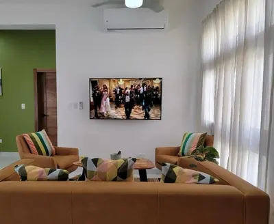 a living room with two couches and a table at Villa Serene Breeze Private Pool Sosua Ocean Village in Sosúa