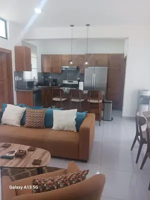 a living room and kitchen with a couch and a table at Villa Serene Breeze Private Pool Sosua Ocean Village in Sosúa