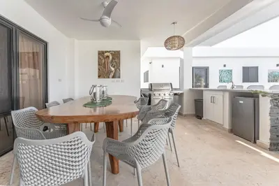 a kitchen and dining room with a wooden table and chairs at Kcasama Castle Villa 1108 in Sosúa