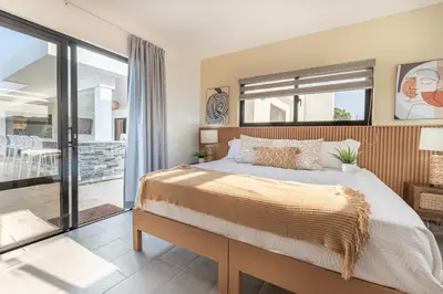 a bedroom with a large bed and a balcony at Kcasama Castle Villa 1108 in Sosúa