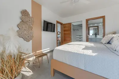 a bedroom with a white bed and a tv at Kcasama Castle Villa 1108 in Sosúa