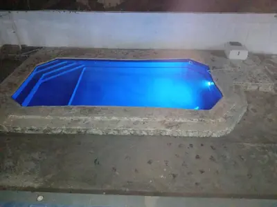 a blue swimming pool in the floor of a room at Apartamentos grigri in Río San Juan