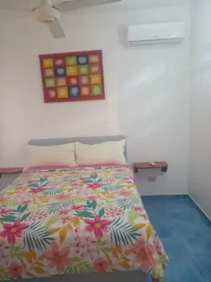 a bedroom with a bed with a colorful comforter at Apartamentos grigri in Río San Juan