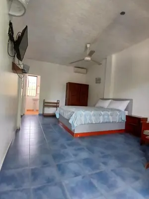 a bedroom with a bed and a tiled floor at Apartamentos grigri in Río San Juan