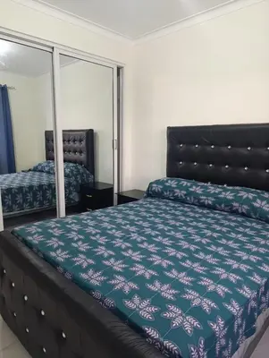 a bedroom with a bed and a mirror at Residencial cayena del este Santo Domingo este in La Grúa
