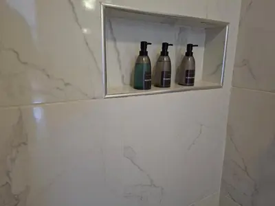 three bottles of wine sitting on a shelf in a bathroom at Hermosa villa familiar cucu's home beach in Río San Juan