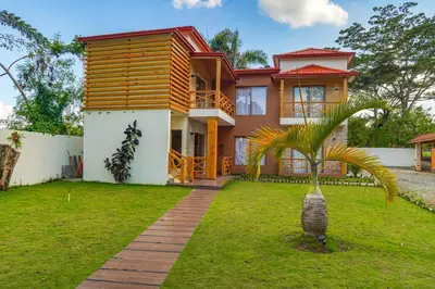 a house with a palm tree in front of it at Villa my place in Bonao