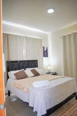 a bedroom with a large bed with two pillows at Villa my place in Bonao