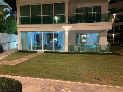 a large house with a lawn in front of it at Luxury Oceanfront Condo in Sosúa