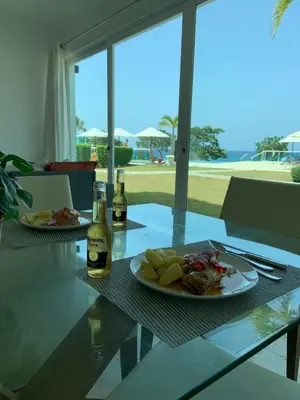 a table with a plate of food and two bottles of wine at Luxury Oceanfront Condo in Sosúa