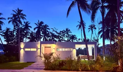 a white house with palm trees at night at Charming Villa GUGI #80 in Palmeras de Coson, Las Terrenas in Las Terrenas