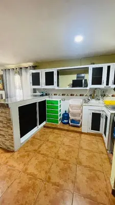 a large kitchen with white cabinets and a tile floor at beachfront apartment in La Puntica de Juan Dolio