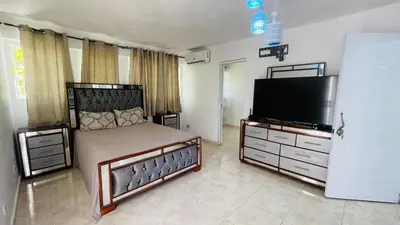 a bedroom with a bed and a flat screen tv at beachfront apartment in La Puntica de Juan Dolio