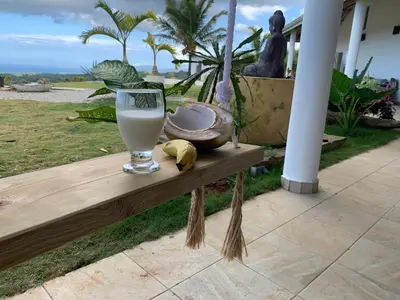 a glass of milk sitting on a wooden bench at Villa Brisa del Caribe in Las Terrenas