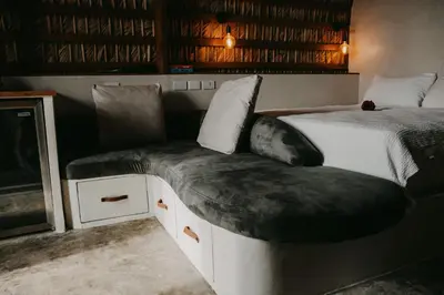 a bedroom with a bed with a cushion on it at OYA New Earth Private Jungle Cabin with Individual Campfire in Jamao al Norte