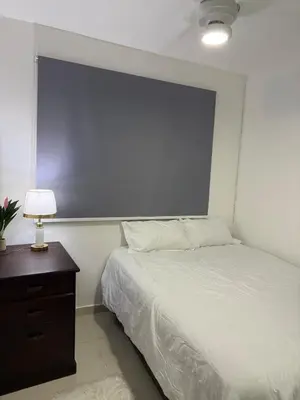 a bedroom with a bed and a table with a lamp at Apartamento en Santo Domingo Pablo mella morales in Hato Nuevo