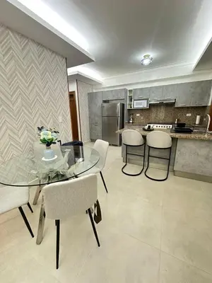 a kitchen with a glass table and some chairs at Chic City Apartment Walk to Everything! in Santo Domingo