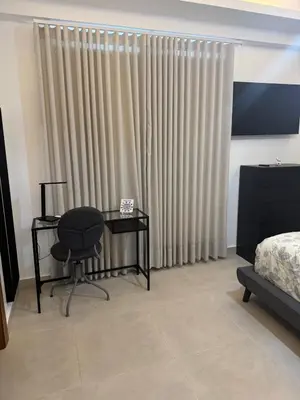 a bedroom with a desk and a chair in front of a window at Chic City Apartment Walk to Everything! in Santo Domingo