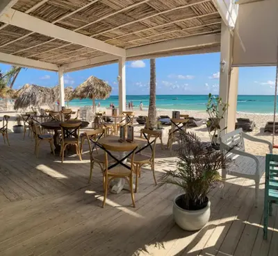 a restaurant on the beach with tables and chairs at Playa Privada | Terraza & Piscina • WiFi Rápido in Punta Cana
